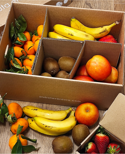 Caja de fruta para oficina con compartimentos, cada uno con un tipo diferente de fruta.